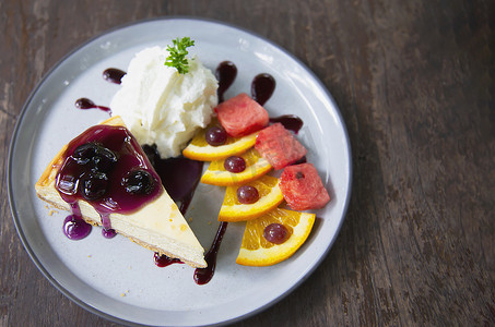 精美菜单摄影照片_色彩缤纷的纽约芝士蛋糕，配有装饰精美的水果片和白盘生奶油 — 蛋糕食谱菜单概念