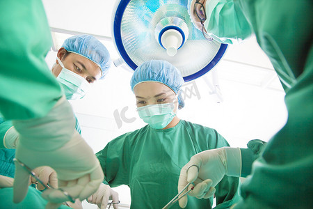牙科手术台摄影照片_外科医生团队在手术室一起工作