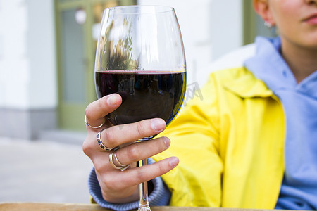 白酒红酒摄影照片_酒杯中的格鲁吉亚红酒、酒精饮料和女人的手