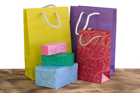粉色购物包摄影照片_木制背景上色彩鲜艳明亮的购物包和盒子