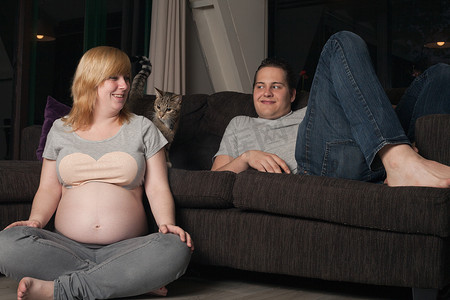 沙发猫摄影照片_怀孕夫妇和家里的猫