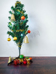 装饰礼物盒摄影照片_用灯装饰的小美丽的圣诞树 礼物盒
