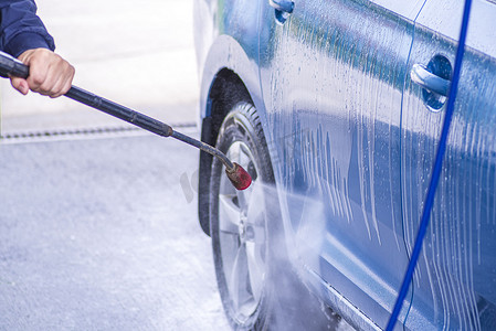 在外面的洗车场用加压水手动洗车。使用高压水清洗汽车。