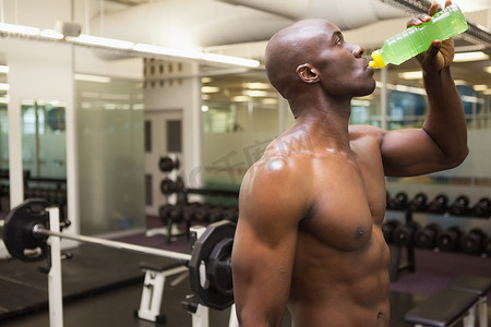 在健身房喝能量饮料的肌肉男