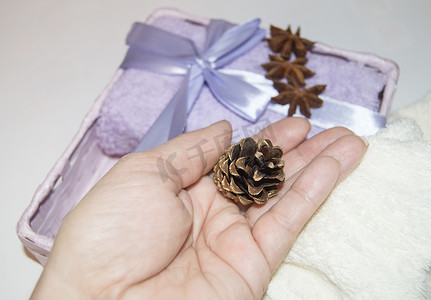 装饰金纸摄影照片_一个女人的手用金锥装饰圣诞礼物，打包毛巾，并为假期做准备