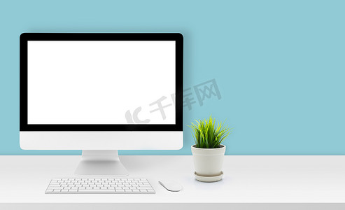 模型台式计算机在办公室的办公桌上显示空白屏幕，工作区与模型计算机屏幕为空，键盘、鼠标、植物和复制空间在家里的桌子上，业务演示概念。