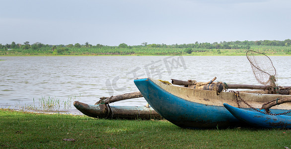 渔民画摄影照片_风景如画的湖边传统斯里兰卡木画渔船