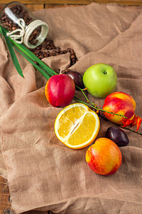苹果桃子摄影照片_在麻布背景的静物画：苹果、桃子、orance、李子