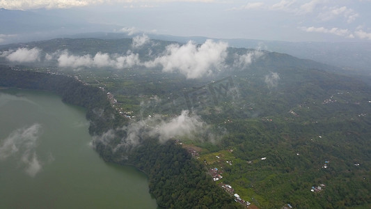 印度尼西亚巴厘岛蓝天旁的热带景观，包括山、Danau Buyan 湖和远处的村庄