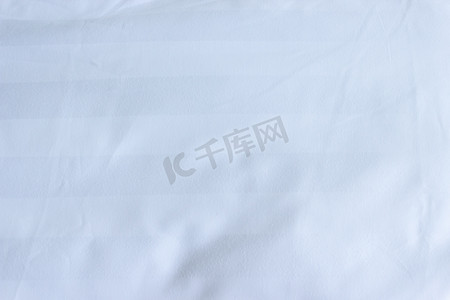 带枕套纹理背面的白色织物床单的顶部视图