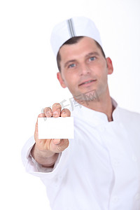 名片餐饮摄影照片_拿着一张空白的名片的厨师