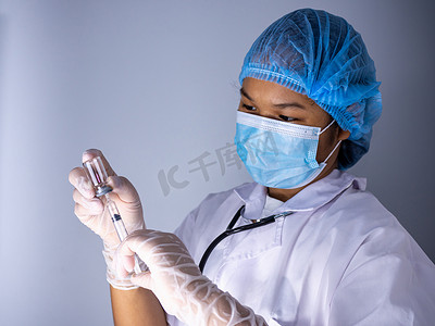 预防疾病知识摄影照片_一位戴着面具和帽子的女医生的工作室肖像。