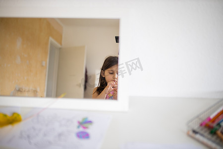 白背景图片摄影照片_白桌上的镜子反射着一个小女孩和一扇白色敞开的门
