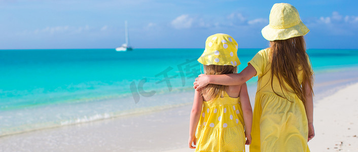 热带海滩上两个小女孩的背影