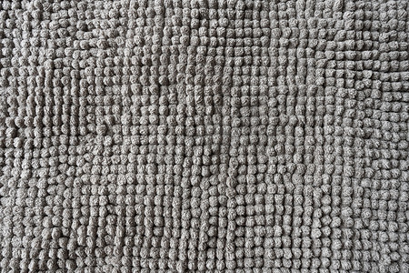 地毯花纹图案摄影照片_由小球制成的灰色毯子的质地。
