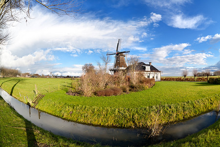 绿色草风车摄影照片_绿色牧场运河旁的荷兰风车