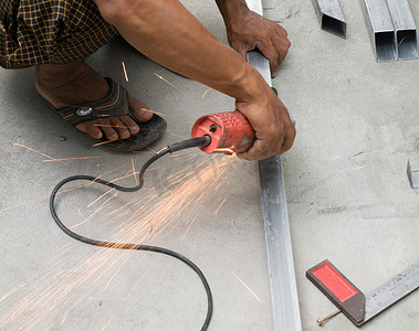 工人用电动砂轮机切割钢材