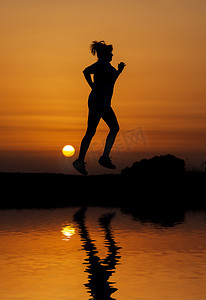 剪影女人在橙色夕阳下奔跑