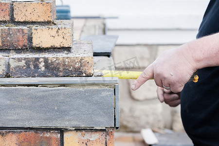 瓷砖工测量并标记切割和铺设瓷砖