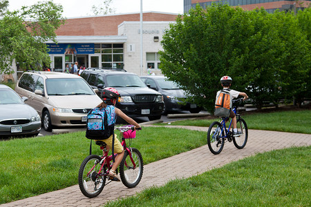 男孩骑自行车上学摄影照片_孩子们骑自行车上学