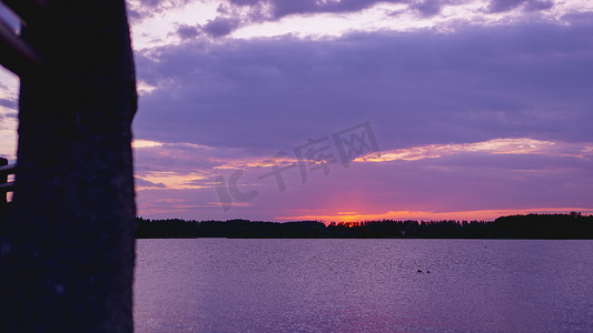 海面天空摄影照片_紫罗兰色紫色日落，天空下的黑海面