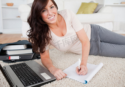 年轻漂亮的女人在 n 上写字时用笔记本电脑放松
