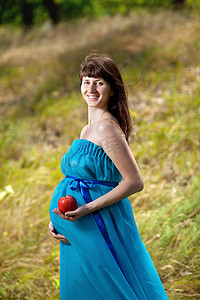 拿着苹果的快乐怀孕女孩