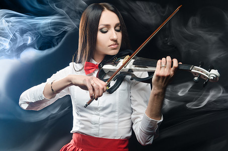 黑色背景中拉小提琴的梦幻女人