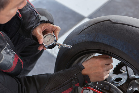 旅行前男子摩托车轮胎手动气压测试