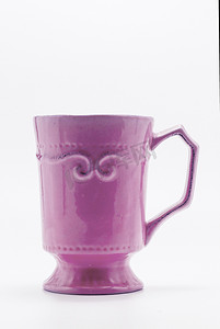 白色背景中突显的一个破旧的紫色杯子