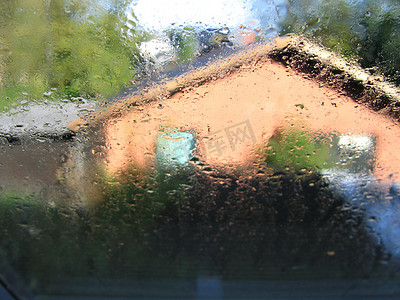 冬天 — 雨滴落在窗户上，背景是房子