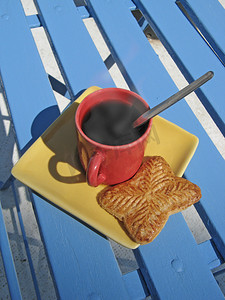 冒热气摄影照片_椅子上冒着热气的咖啡杯