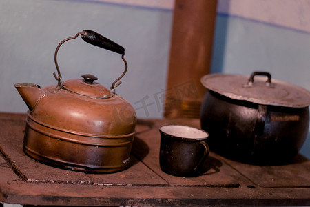 深色 kitc 老式铸铁炉上的旧铝茶壶