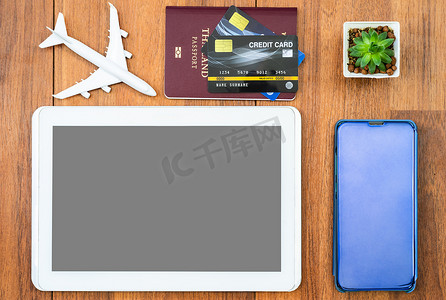 在木桌上模拟信用卡和数字平板电脑的顶视图护照
