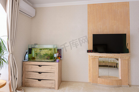 房间的一个角落，有一个水族馆，挂着空调和一个风格化的电视地方