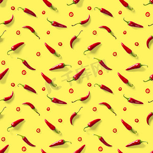 在黄色背景上由红辣椒或辣椒制成的无缝图案。
