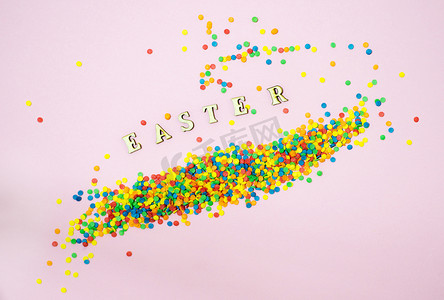 彩色折扣摄影照片_抽象的复活节贺卡，散落着彩色糖果球和字母。