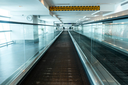 冠状病毒大流行期间空荡荡的机场走廊中的自动人行道。