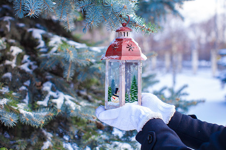 雪冬日冷杉树枝上的圣诞灯笼