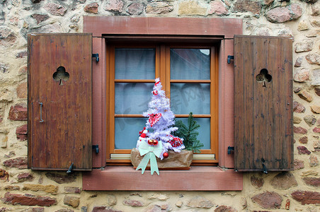 窗台上切下三叶草和圣诞装饰（白色小树）的百叶窗