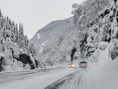 驾车摄影照片_驾车穿过挪威的雪路和风景。