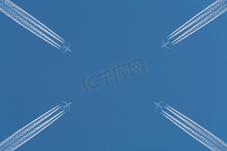 流线条摄影照片_天空中的飞机有尾迹。