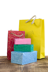 粉色购物包摄影照片_木桌上色彩鲜艳的购物包和盒子