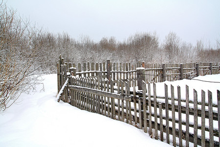 冬雪上的旧木栅栏