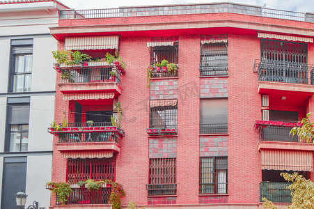 西班牙巴伦西亚一栋带窗户和阳台的住宅楼的粉红色砖墙