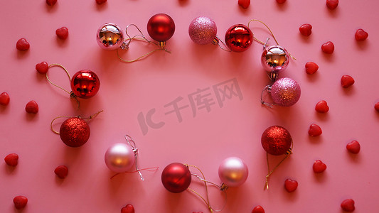 粉红色桌面视图上由圣诞球制成的节日框架