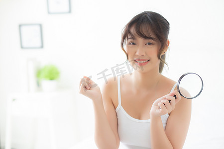美丽的亚洲年轻女性对粉刺皮肤的放大感到满意，