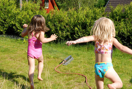斯堪的纳维亚生活方式 — 在花园里奔跑的快乐女孩