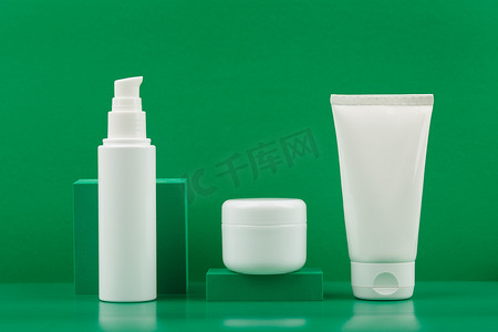 面霜或乳液、带香脂或面罩的白色罐子、手霜或带绿色背景几何道具的身体霜