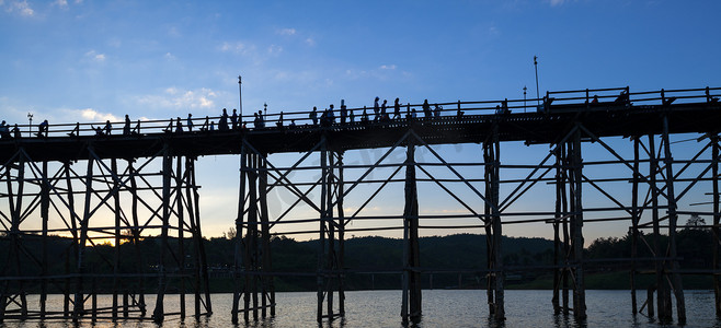 坎木头摄影照片_Utamanusorn 桥 (Mon Bridge) 的剪影，由木头制成